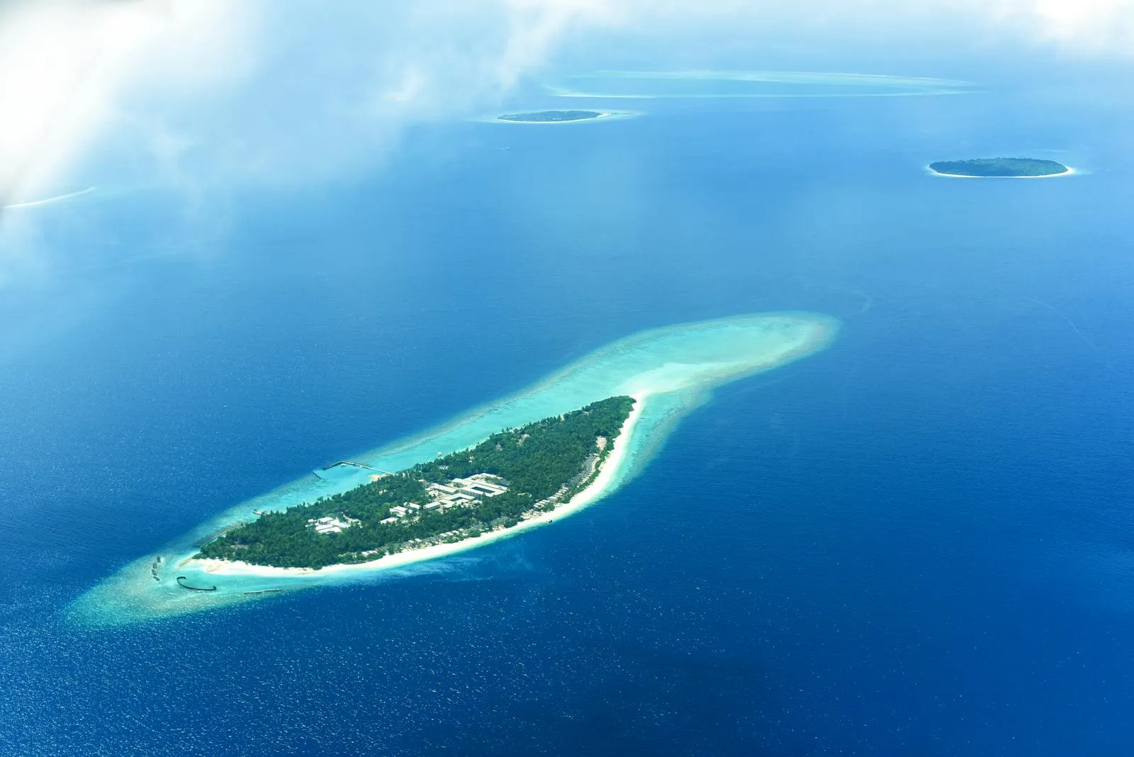 Aerial view of a Maldivian island surrounded by deep blue ocean